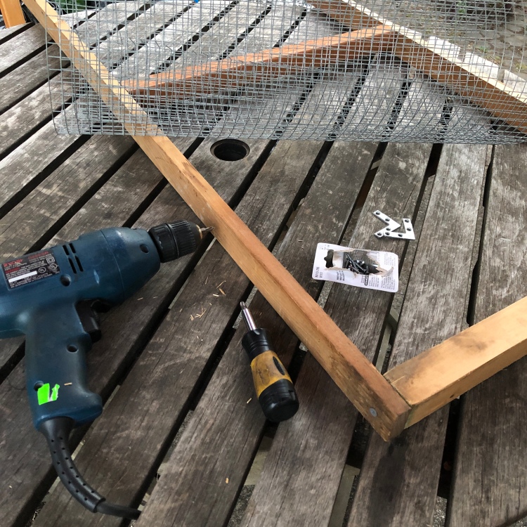 power drill next to a wooden frame that is being built